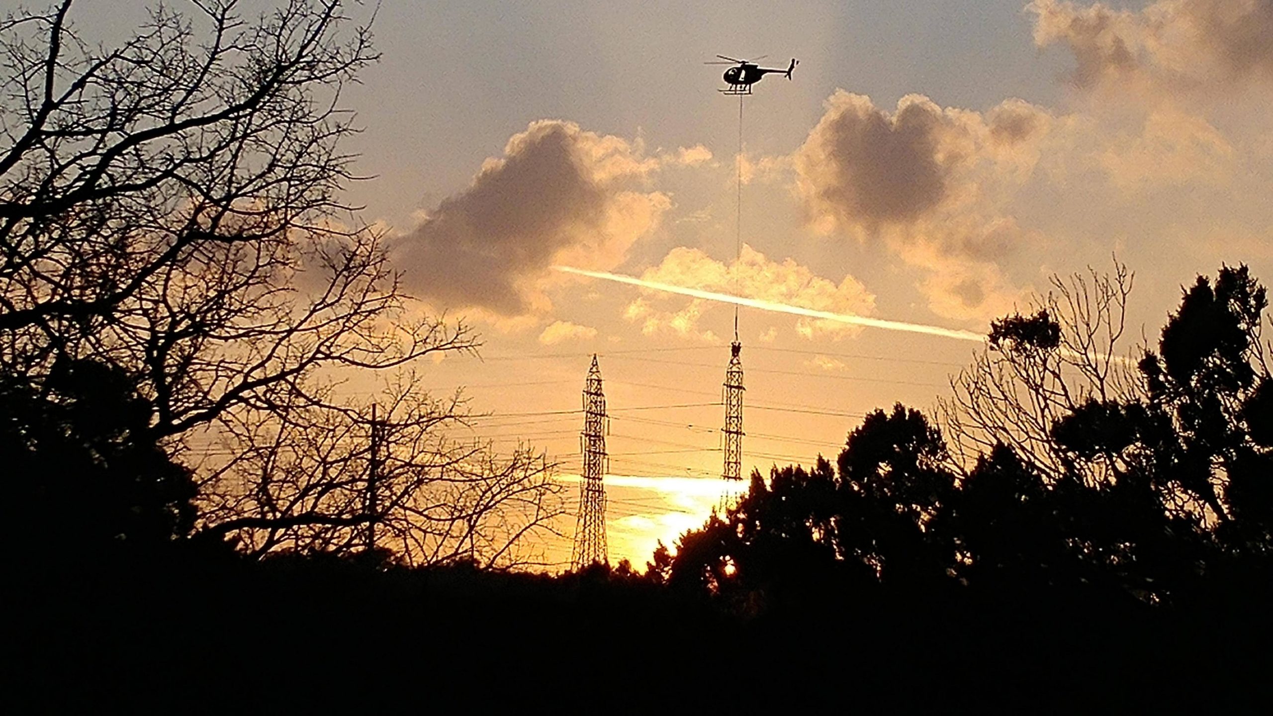 Paused my hike to snap this picture of a helicopter working on some power lines at sunset